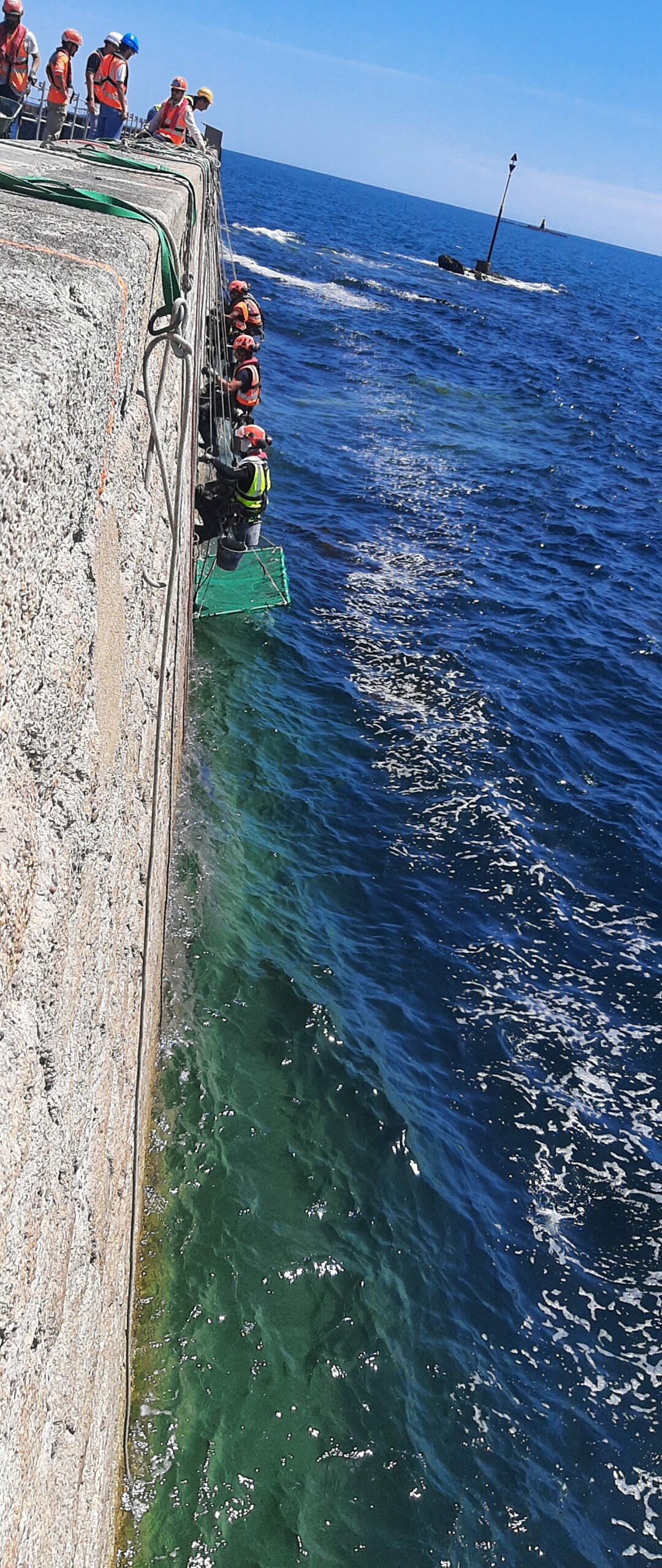 Photos de cordistes au travail sur la digue de Lomener en travaux